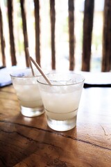 Refreshing Cloudy White Drinks with Ice and Straws on Wooden Table