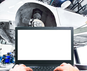 Blank screen on a laptop in an auto shop. Perfect for promoting engine fault finding and high-tech vehicle maintenance.