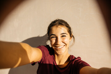 Happy woman recording a selfie outdoors on sunny day