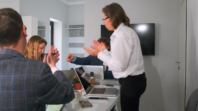 manager directs team handover, assertive leader guides team through document exchange in meeting, project manager confidently manages team handover with document distribution in small meeting room