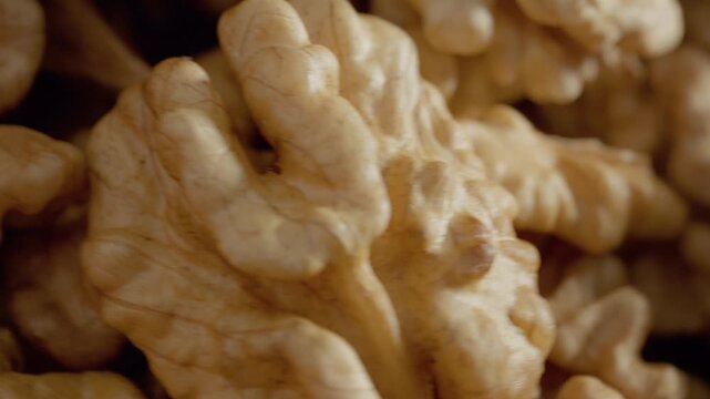 Explore the intricate texture and structure of walnut kernels up close. This detailed macro shot showcases the unique shapes and colors of this popular nut.