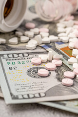 Dollar bill and a set of medicine pills. Rising costs of medical care. Reliefs for buying medicine.Pills in capsules scattered on US dollars currency.Concept of health care in USA.