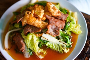 Close-up of Thai street food sukiyaki with fried pork and vegetables