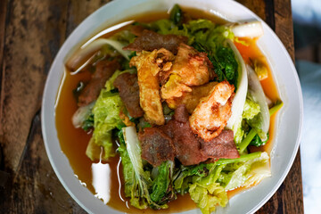 Thai street food sukiyaki soup with fried pork and vegetables