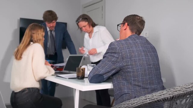 startup founders discuss product ideas actively, group of entrepreneurs brainstorming new product concept, caucasian founders collaboratively develop product pitch using notes and gestures in lively