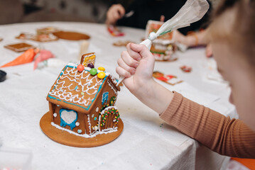 Children happily decorating gingerbread houses with icing and candy for a festive Christmas holiday activity