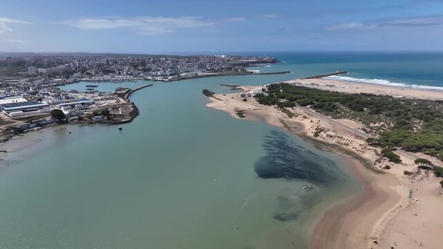 Cinematic shot of the Loukkos River estuary in Larache, near the ancient site of Lixus, highlighting the calm waters, coastline, and natural landscape.
