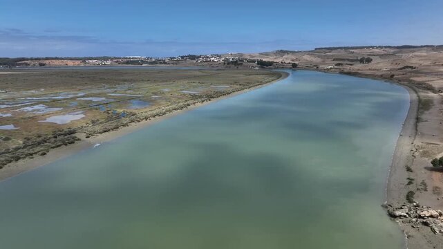 High-resolution close aerial shot of the Loukkos River winding gently toward its estuary near Larache, capturing natural water flow and surrounding landscape.