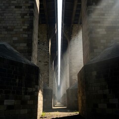 A dramatic view of a modern, industrial-style bridge with towering stone pillars and beams creating a symmetrical perspective with mist and sunlight highlighting the structure