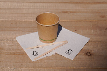 Naklejka premium FSC paper cup logo brand and text sign with recyclable and recycled paper napkins on a wooden table