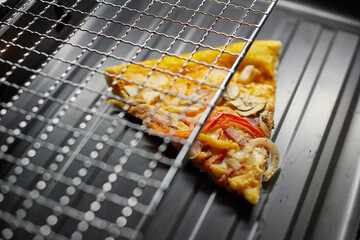 Fresh slice of Bavarian pizza on a grill grate