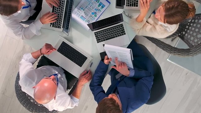 team analyzing budgets, calm team reviewing financial plans, group discussing forecasts over spreadsheets in office, team collaboratively planning budgets using laptops and spreadsheets peacefully