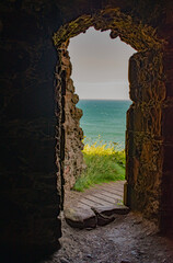 Obraz premium Stonehaven, Scotland, United Kingdom: the North Sea seen from an opening of an ancient building of Dunnottar Castle, a ruined medieval fortress on a rocky headland in the northeast coast 