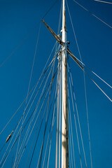 Close up of yacht mast and sail on sky background. Sailing boat part.