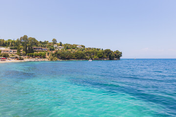 Picturesque Mediterranean coastal village overlooking turquoise bay with luxury hillside homes and crystal clear waters.