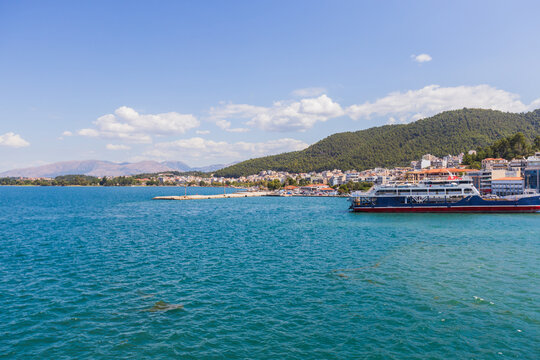 Coastal town with ferry and mountains on a sunny day