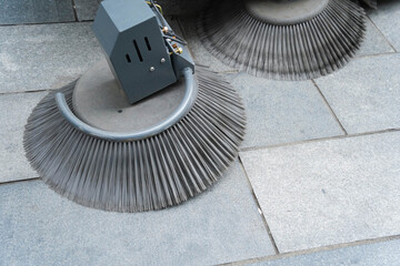 Special street cleaning machine with rotating broom sweeping the road.