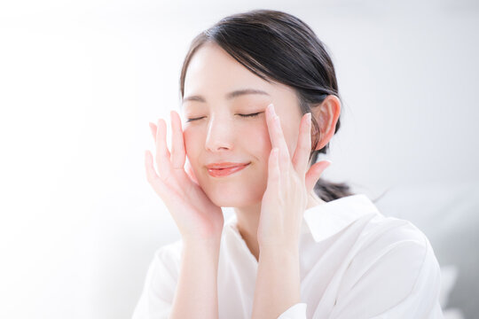 白シャツで清潔感あふれる若い女性の笑顔とスキンケア・美肌のビューティーポートレートのクローズアップ　目を閉じる目元のケア