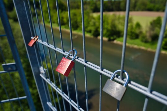 Love lock attached to a metal railing. A modern custom in which couples engrave their names and a date on a padlock, attach it to a public place, and throw away the key to symbolize their eternal love