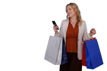 Happy woman holding shopping bags and using smartphone, smiling while shopping online or texting, transparent background