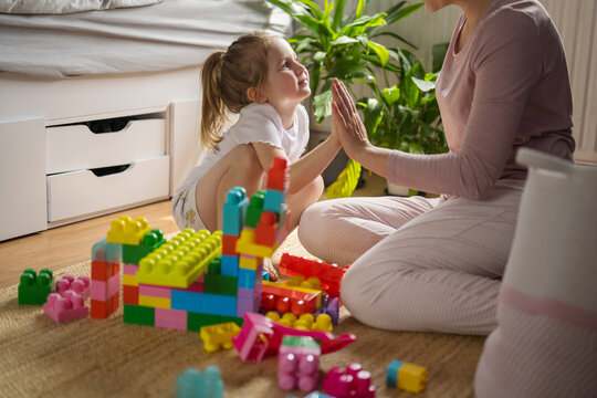 Mother and daughter playing with colorful blocks on the floor