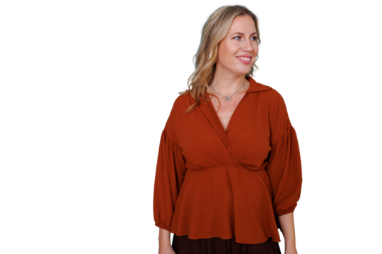 Blonde woman in a rust-colored blouse smiling and looking away on a transparent background, offering space for copy