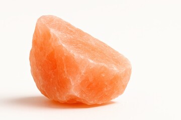 Brightly lit pink salt crystal on pure white background side view with sharp facets and subtle grain texture for mineral wellness spa and culinary themes