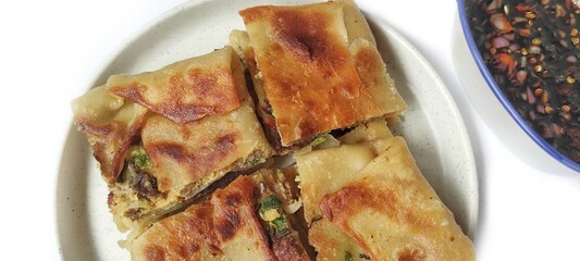 Martabak Telor with Soy Sauce Served On a Plate. Traditional Indonesian Street Food. Food Photography Presentation. Isolated on White Background