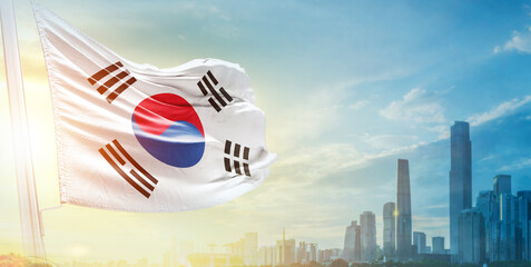 South Korea flag wavering in beautiful clouds with building skyline. The flag with drone shot in beautiful sky. Korean national flag for independence day.
