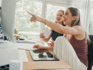 Women collaborating in a bright home office using technology