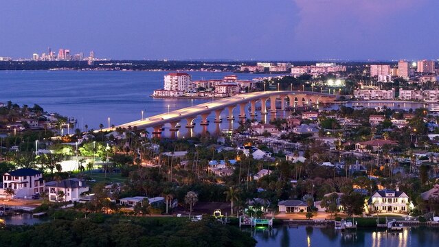 Aerial view of the bridge stretching over the tranquil water, connecting the vibrant cityscape under the pastel sky, St. Pete Beach, Florida, United States.