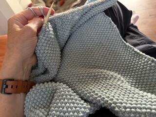 hand with knitting needles