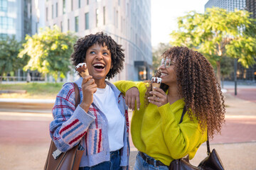 Happy friends enjoying ice cream in city