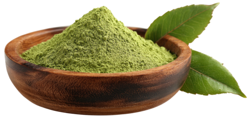 A wooden bowl overflowing with vibrant green powder, two leaves beside it