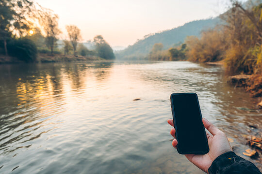 Disconnecting from technology by the serene riverside at sunset Generative AI