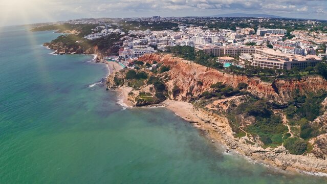 Aerial top drone view Algarve coastline turquoise ocean water rocky cliffs sandy beach vacation trip resort town buildings Atlantic seascape summer travel destination scenic Portugal coastal landscape