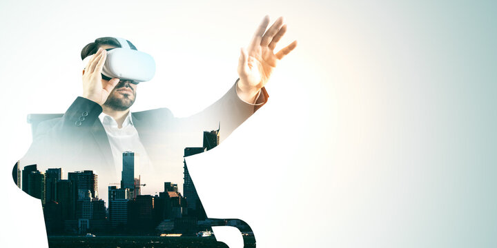 Businessman wearing virtual reality headset interacting with VR environment over cityscape double exposure on light background.