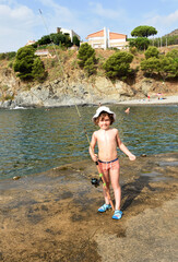 Boy holding a fishing rod on the Costa Brava, Colera, La Rovellada