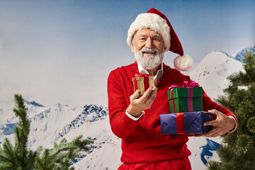 Handsome senior man celebrating winter with festive gifts in snowy mountain backdrop