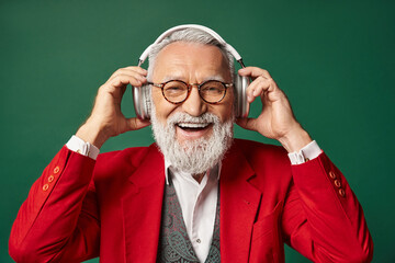 Joyful senior man enjoying music in a vibrant winter setting with headphones on