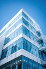 Obraz premium Modern glass and steel building against clear blue sky