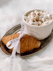 Cup of coffee and croissant on a silver tray