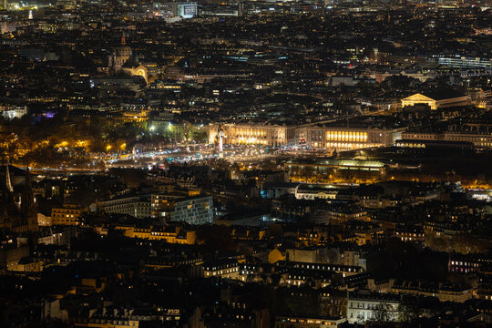 Aerial view of the illuminated Louvre Museum and Tuileries Garden glow warmly amidst the twinkling cityscape, a beacon of art and history under the night sky, Paris, Ile-de-France, France.