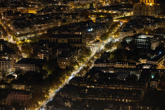 Aerial view of the city lights paint a mesmerizing tapestry across the Parisian landscape, illuminating the streets and buildings below, Paris, Ile-de-France, France.