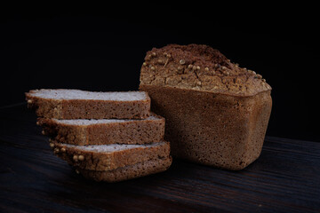 Sliced buckwheat bread on dark wooden background.