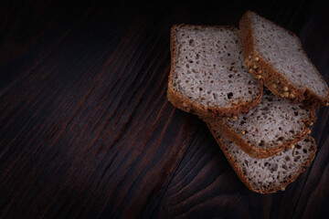 Sliced buckwheat bread on dark wooden background.
