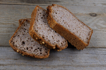 Sliced buckwheat bread on a Half a loaf and pieces of sliced buckwheat bread on a dark wooden background. wooden background.