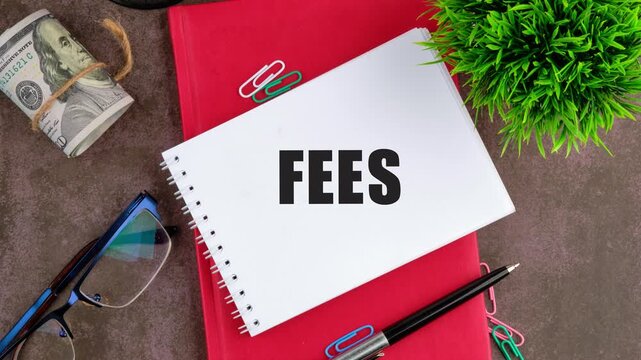Business and finance concept. Animation of the FEES text on the sheet, a close-up view from above