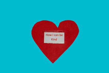 love heart symbol with words printed on it "how i can be kind" on a blue background