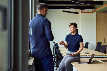 Obraz premium Professional Office Conversation Between Colleagues About Collaboration and Planning in a Modern Workspace